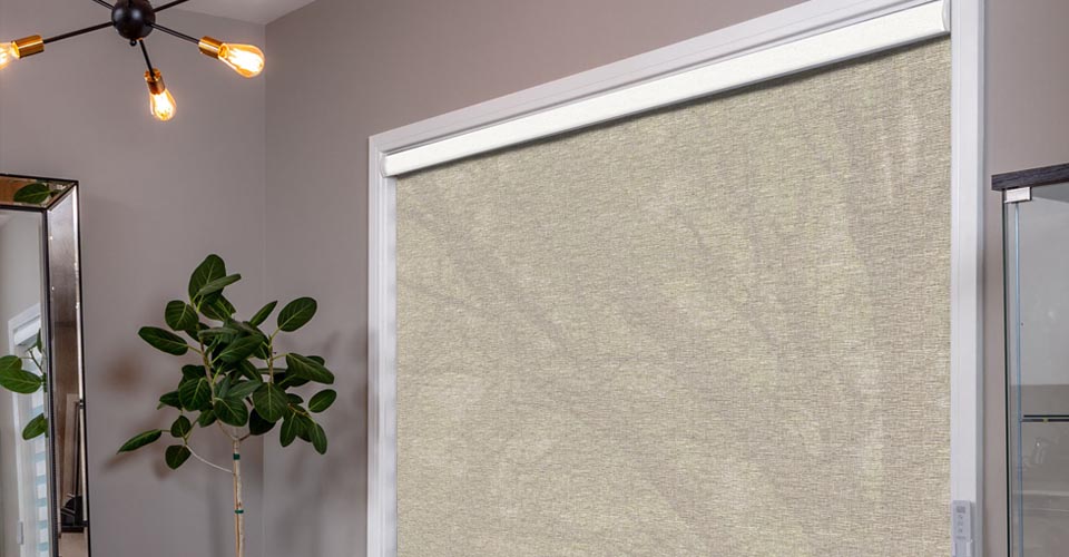 A textured roller shade lowered over a wide window in a modern room